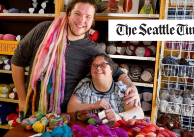 Two people smiling at a knitting yarn supplier. The Seattle Times.