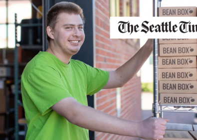 Man pushing a cart with boxes. The Seattle Times.