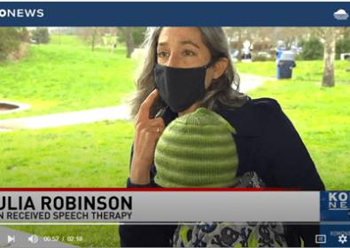 Woman wearing a mask on the news. Julia Robinson, son received speech therapy.